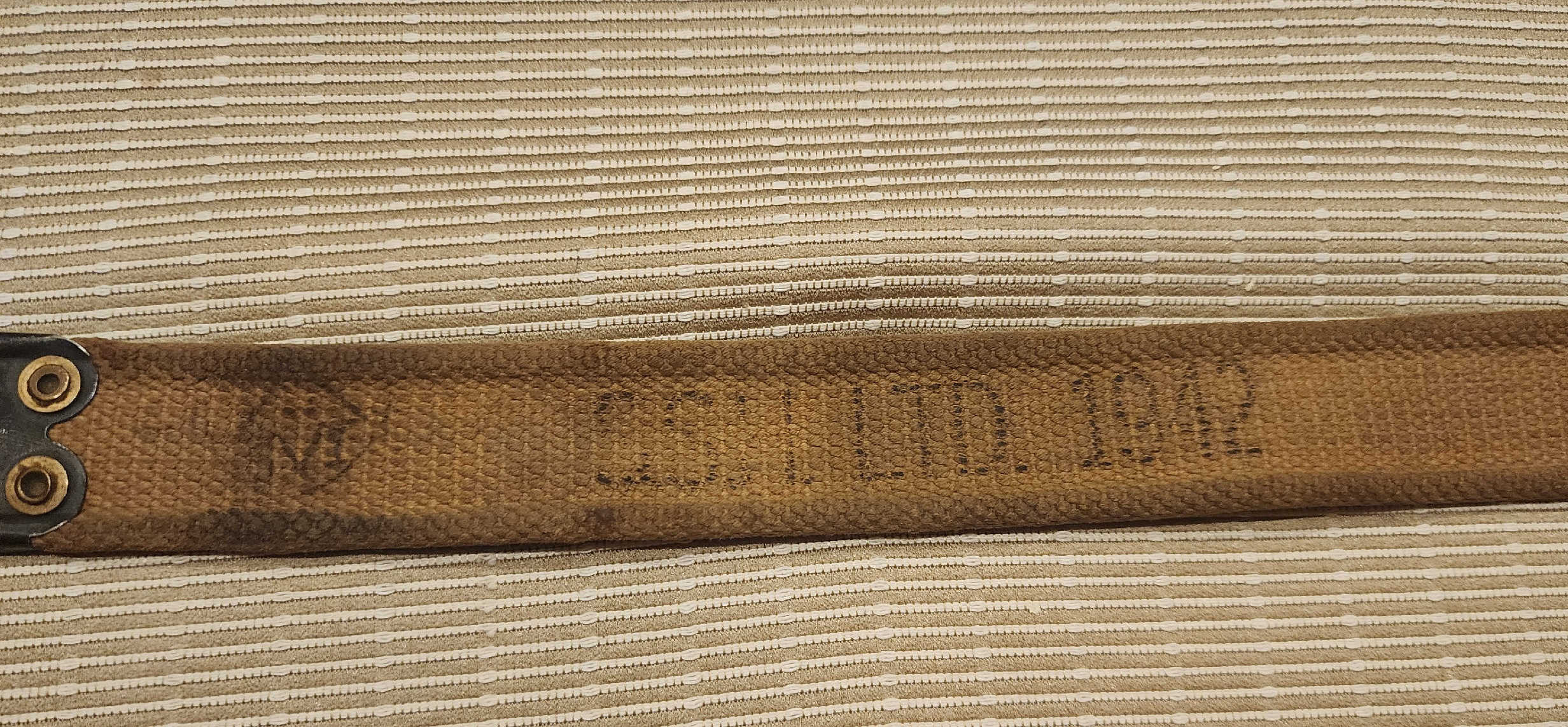 Close view of S.S.H. LTD 1942 stamp and blackened brass hook on Enfield sling