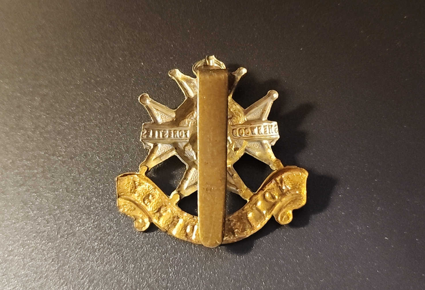 Rear view of Sherwood Foresters cap badge with brass slider fastening