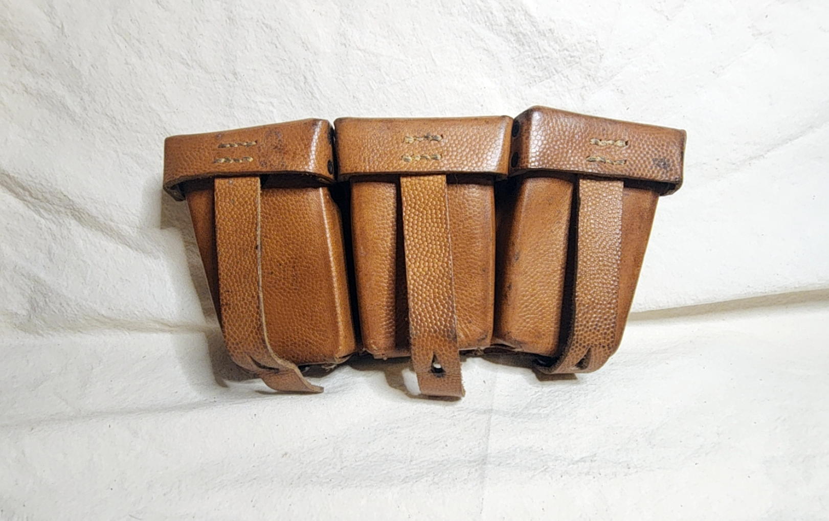 Front view of brown leather German Kar98k ammunition pouch with three lids and closure straps