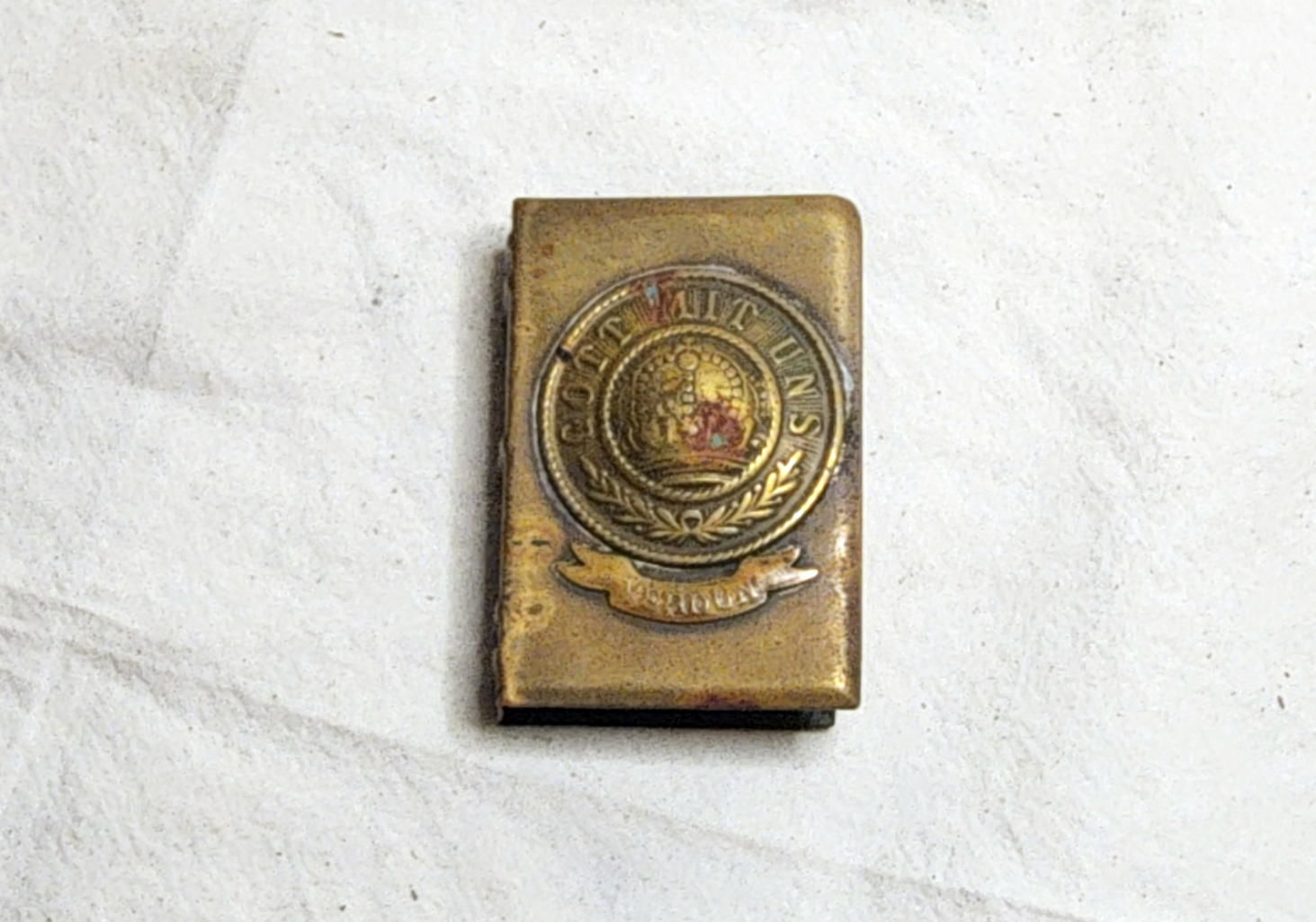Front of the brass matchbox holder with Prussian crown, GOTT MIT UNS motto, laurel decoration, and small scroll
