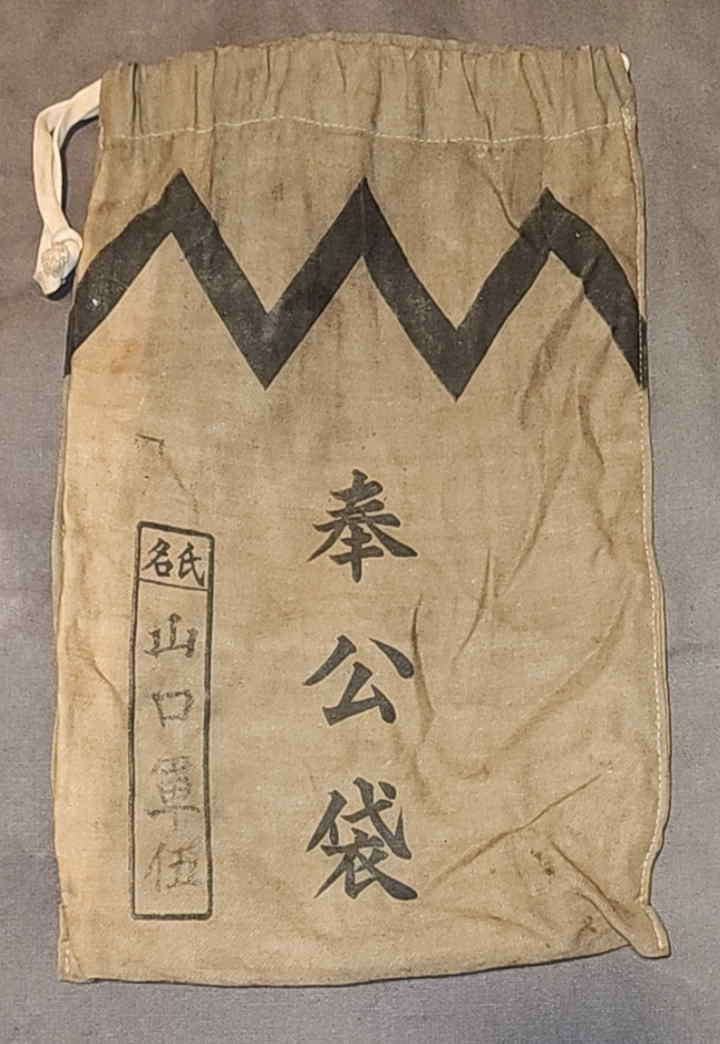 Front of Japanese military service bag showing bold 奉公袋 title, zig-zag band, and owner name panel