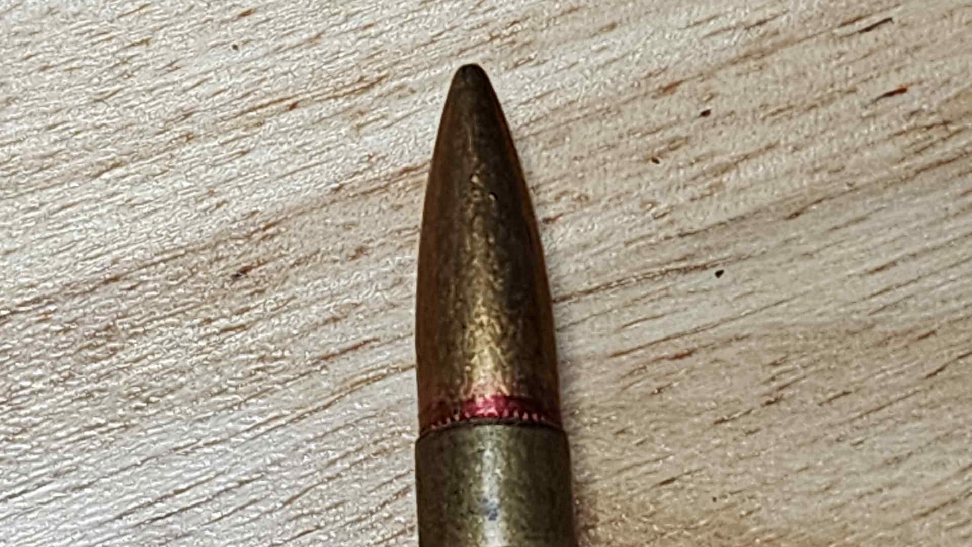 Close-up of Type 99 bullet and case neck showing red lacquer sealant