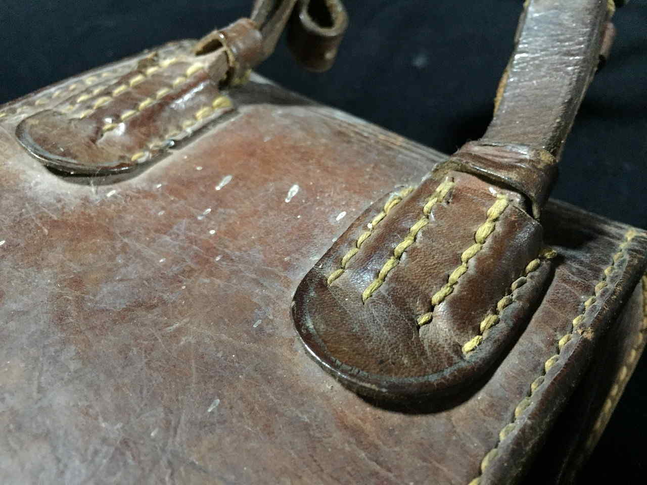 Close view of leather strap mount and stitching on Japanese leather map case