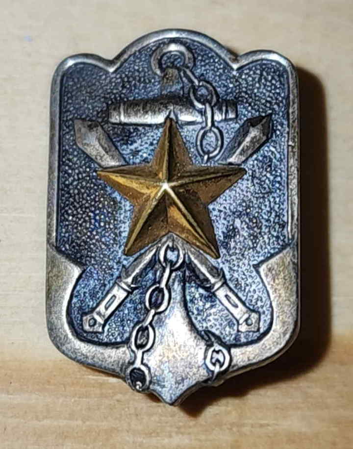 Front of Imperial Japanese Military Reservist Association badge showing gilt star over anchor, chain, and crossed-weapons design