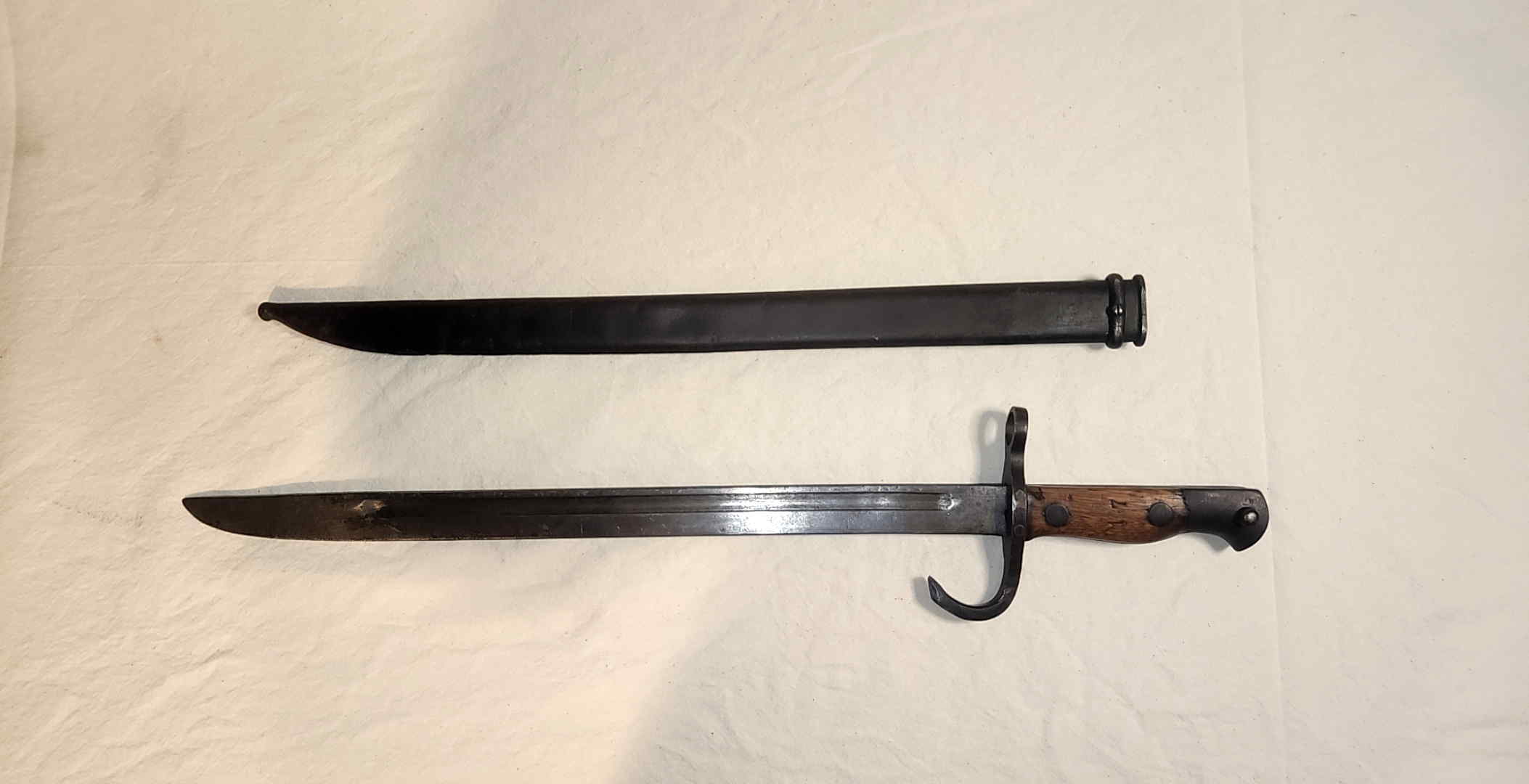 Japanese Type 30-pattern school training bayonet displayed beside its steel scabbard
