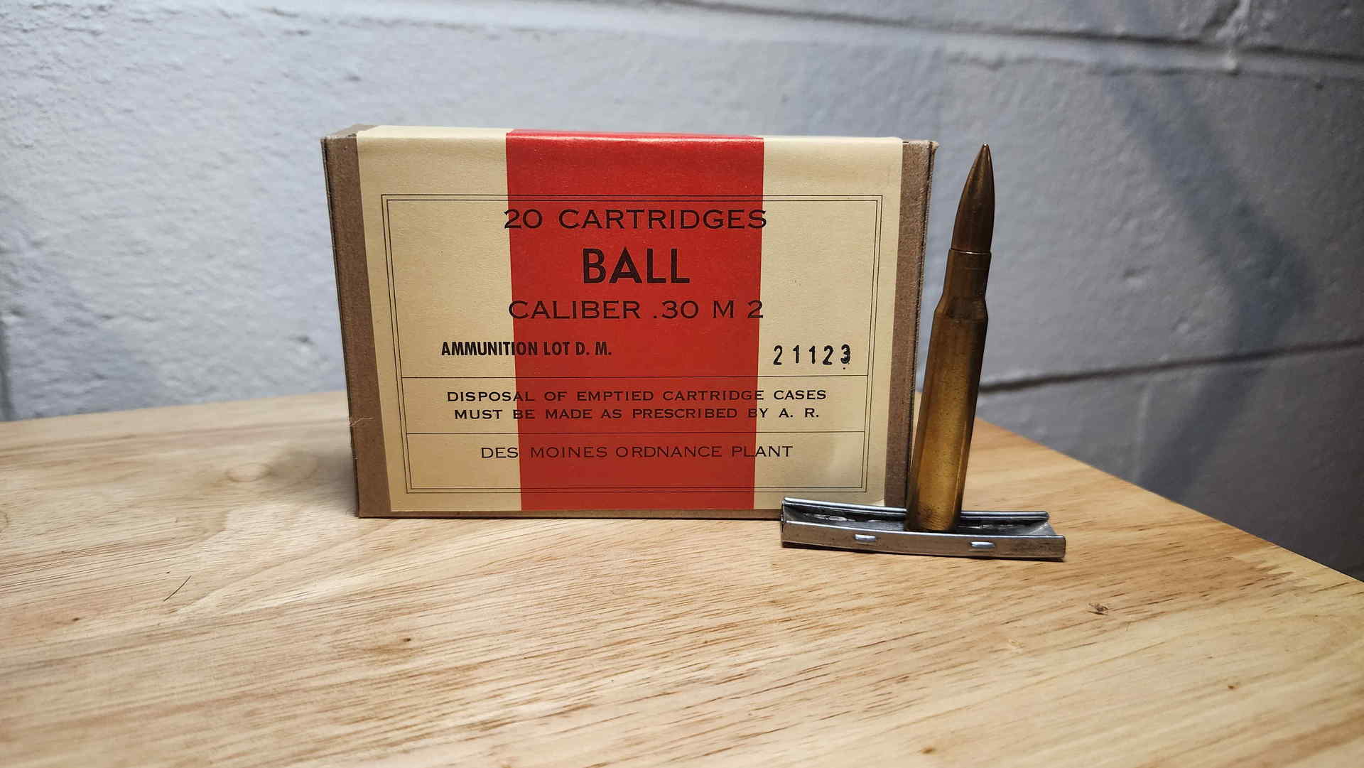 Des Moines Ordnance Plant 20-round Ball Caliber .30 M2 carton, lot D.M. 21123, displayed with a cartridge