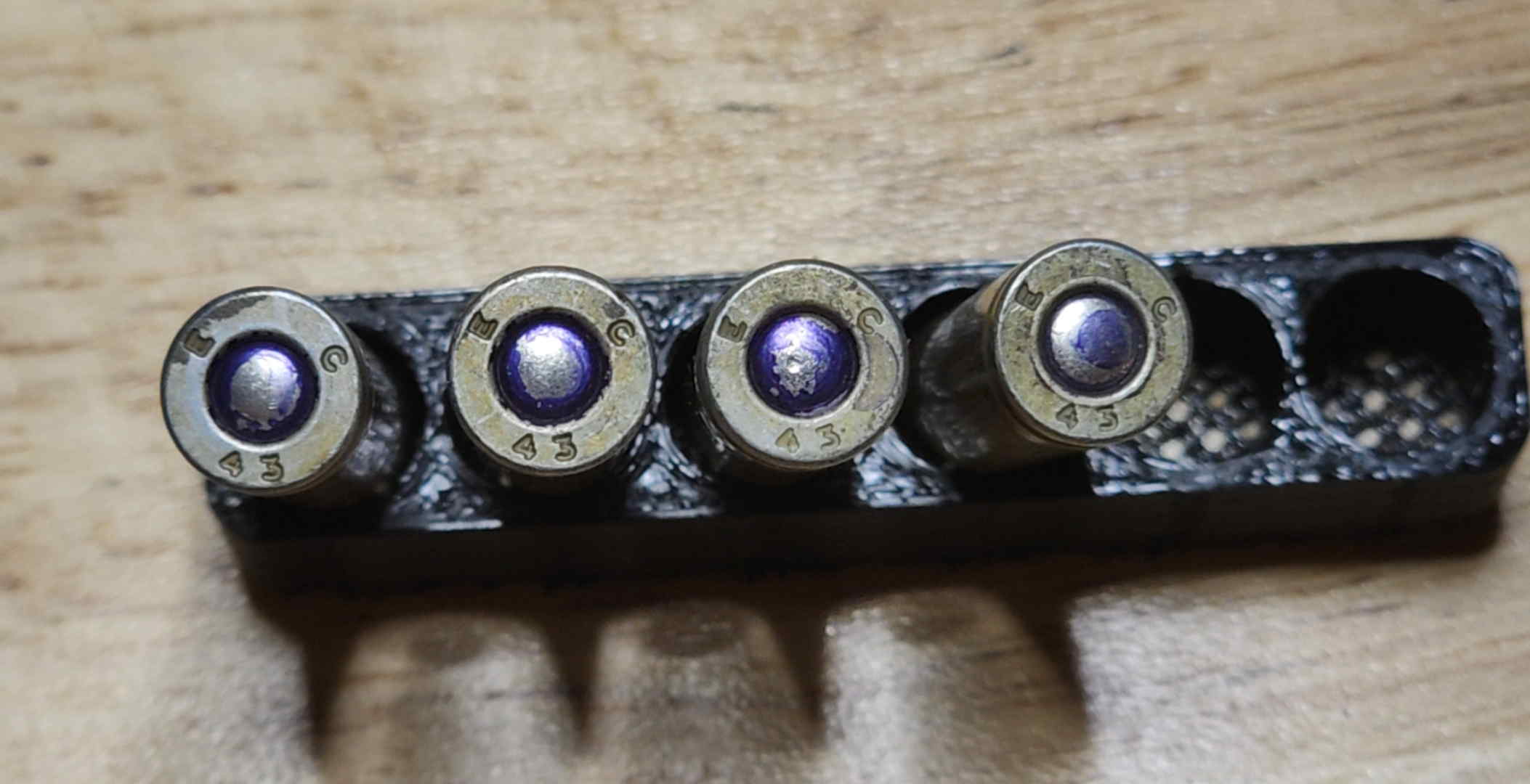 Four EC 43 headstamps with purple primer annulus sealant on steel-cased .30 Carbine cartridges