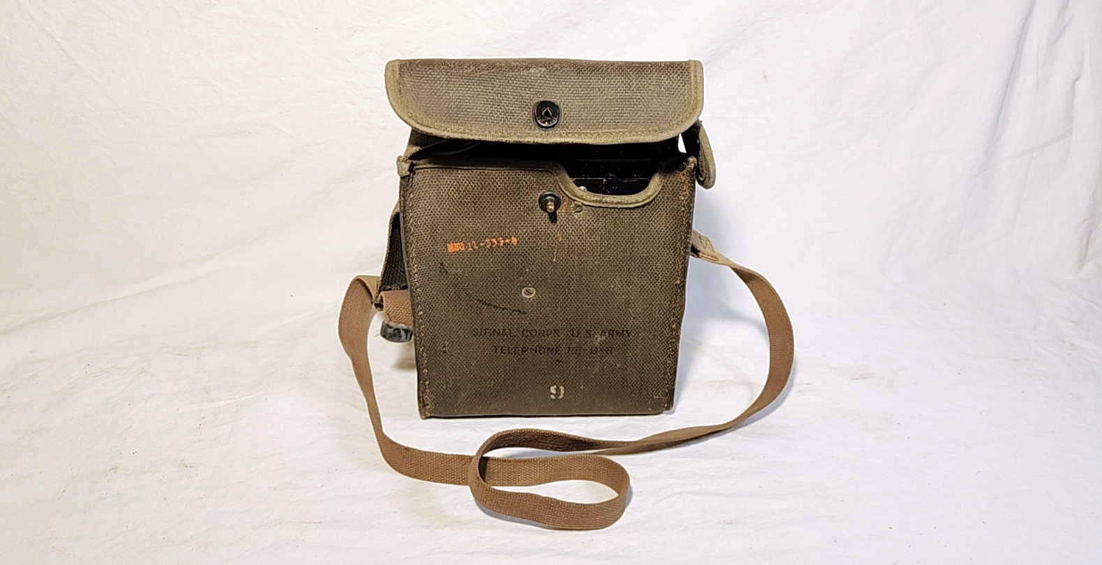 Complete set, front view of a U.S. Army Signal Corps EE-8-B field telephone in a green canvas case with shoulder strap