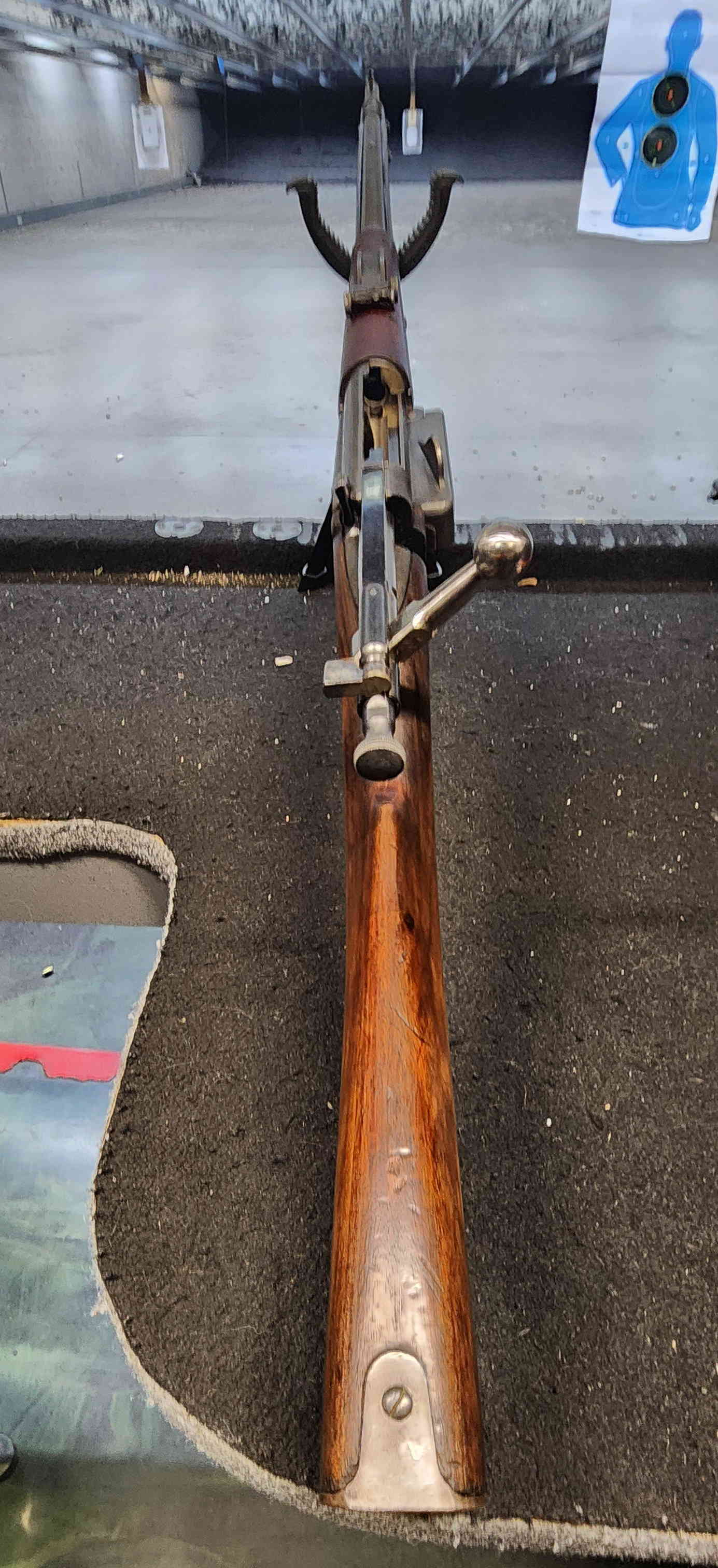 Krag rifle aligned downrange at indoor range, bolt open