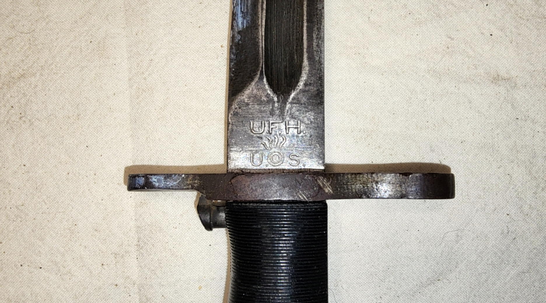 Close view of U.F.H. above the U.S. Ordnance shell-and-flame marking on the blade
